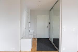 pasillo con paredes blancas y espejo en Riverside Suites by BookLapland, en Rovaniemi 22 fotos más