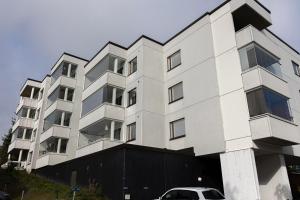Un edificio blanco con un coche aparcado delante. en Riverside Suites by BookLapland, en Rovaniemi
