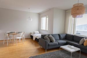 una sala de estar con un sofá y una mesa en Riverside Suites by BookLapland, en Rovaniemi