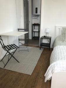 a room with a table and a chair and a bed at Chambre du Haras Cour Lozey in Sainte-Marguerite-des-Loges