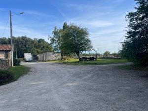 a dirt road with a building and a tree at chambre 4 personnes avec entrée indépendante , grand parking, salle de bain, wc in Confolens +6 photos