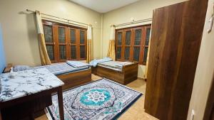 NārāyangarhChitwan Comforts Apt 2的有三张床和两扇窗户的房间