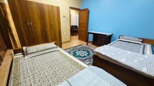 NārāyangarhChitwan Comforts Apt 2的带两张床的房间和一个带书桌的房间