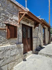 an old stone house with a wooden door at John' s House in Omodos in Omodos