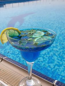 a blue drink sitting next to a swimming pool at All Seasons Hotel Al Ain - Previously City Seasons in Al Ain