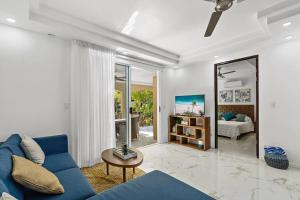 塔马林多Gav10 Modern Pool Side Condo in Quiet Area of Tam的客厅配有蓝色的沙发和镜子