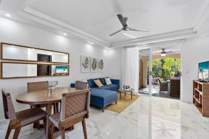 塔马林多Gav10 Modern Pool Side Condo in Quiet Area of Tam的客厅里有一张蓝色的沙发和一张桌子