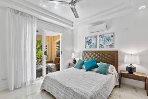 塔马林多Gav10 Modern Pool Side Condo in Quiet Area of Tam的白色卧室配有蓝色枕头的床 更多13张照片