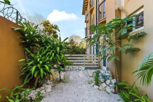 塔马林多Gav10 Modern Pool Side Condo in Quiet Area of Tam的两座植物林立的建筑和楼梯之间的小巷