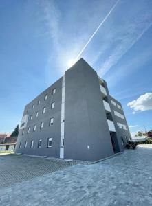 a large building with the sun behind it at Apartman Danijela in Popovača
