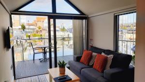 リンカーンにあるLincoln Floating Holidaysのソファと大きな窓のあるリビングルーム