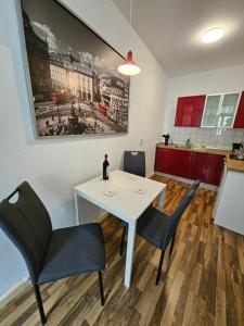 a dining room with a white table and chairs at FERIENWOHNUNG 50m2 APARTMENT in ZITTAUER STADTZENTRUM INNENSTADT INNENRING TOP LAGE - WOHNEN AUF ZEIT IN ZITTAU - 1 RAUM WOHNUNG in Zittau