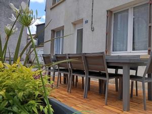 eine Terrasse mit Tisch und Stühlen auf einem Deck in der Unterkunft Les meublés de Louis-Marie, 2 appartements indépendants pour 4 personnes, 8 personnes au total, proche du Puy du Fou in Saint-Amand-sur-Sèvre