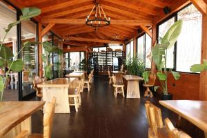 a restaurant with wooden tables and chairs and plants at Posh villa 1 in Kavajë