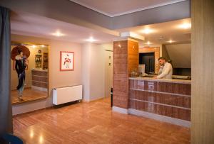 a man standing at a counter in a kitchen at Hotel Maroussi in Athens