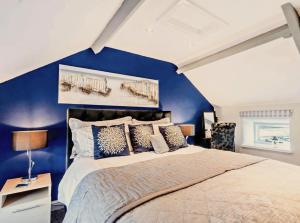 ein Schlafzimmer mit einem großen Bett mit blauen Wänden in der Unterkunft Charming Shepherd's Cottage, Pets Welcome,parking in Bridgend