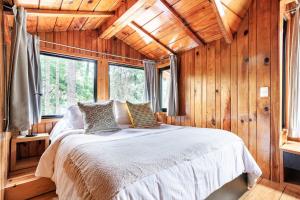 une chambre avec un lit dans une cabane en bois dans l'établissement Cabaña en el corazón de Avandaro, à Avándaro