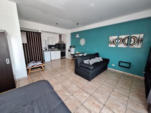 a living room with a black couch and a blue wall at Hermoso departamento en complejo residencial in Tigre