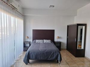 a bedroom with a bed and a large window at Hermoso departamento en complejo residencial in Tigre +15 photos