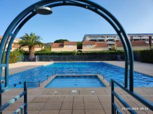 a large swimming pool with an arch over it at Studio cabine tout équipé in Le Lavandou