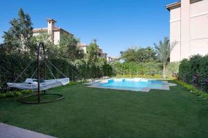 a swing in a yard with a swimming pool at 4 master bedrooms villa with private swimming pool in Cairo