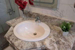 a white sink in a bathroom with a vase of flowers at 4 master bedrooms villa with private swimming pool in Cairo