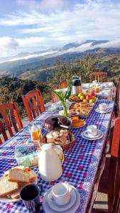 a table with a blue and white table cloth with food on it at Sitio a Moita com Café, Almoço e Janta in Bom Retiro