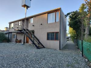 a house with a staircase on the side of it at Sol de montaña, Bariloche. in San Carlos de Bariloche