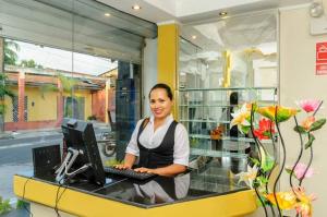 a woman sitting at a desk with a computer at Hotel Confort Amazónico in Iquitos