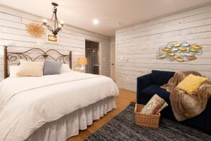 a bedroom with a large bed and a blue chair at Sunfish Suite in Peggy's Cove