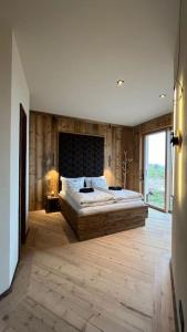 a bedroom with a large bed and a large window at Business Apartment inkl Frühstück in Seiwerath