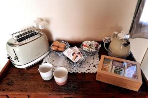 a table with a toaster and a plate of food at Casa Pinocchio appartamento esperienziale in San Giorgio Canavese