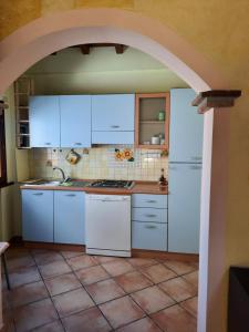 a kitchen with white appliances and an archway at La Casa in Piazza- Pacelli dal 1775 in Vignanello