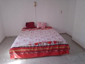 a bedroom with a bed with a red blanket on it at Maison la rose 2 chambres in Mezraya