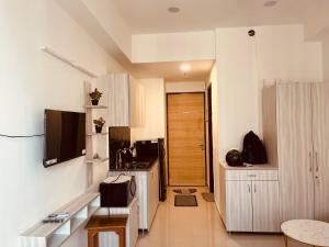 a kitchen with white cabinets and a wooden door at Royal orbit studio in Ghaziabad