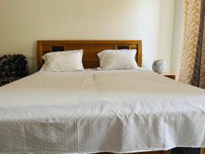 a large white bed with white sheets and pillows at Royal orbit studio in Ghaziabad