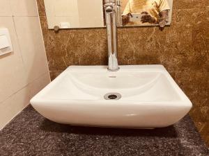 a white sink in a bathroom with a mirror at Royal orbit studio in Ghaziabad +5 photos