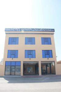 an office building with blue windows at Maan Hotel Apartment in Ḩilf