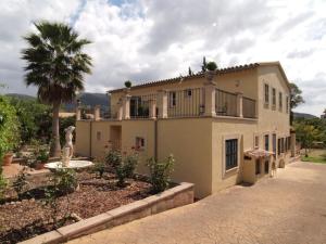 a large house with a palm tree and a courtyard at Villa in Nature with Yoga Room, Peace and Tranquility in Puigpunyent