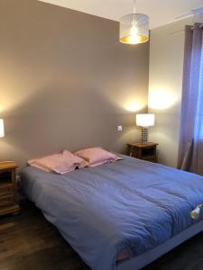 a bedroom with a bed with blue sheets and two lamps at Évadez vous à deux pas de l'océan ! Maison tout confort à seulement 6 min de la plage à vélo in Les Sables-dʼOlonne