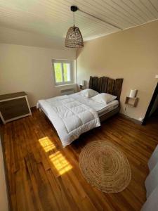 Gîte la petite maison في Soulan: غرفة نوم بسرير كبير وأرضية خشبية