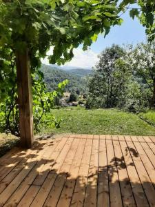 Gîte la petite maison في Soulan: سطح خشبي مطل على شجرة