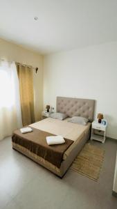 a bedroom with a large bed with two towels on it at Hostel Rocha Marisol in Ponta do Sol