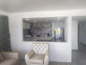 Una sala de estar con una silla y una cocina. en wonderful sea view San Andres island, en San Andrés
