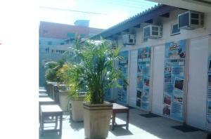 a building with potted plants and signs on it at Pousada Do Futuro in Fortaleza