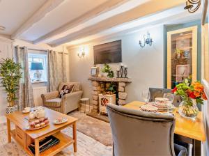 ein Wohnzimmer mit Tisch und Kamin in der Unterkunft Charming Shepherd's Cottage, Pets Welcome,parking in Bridgend