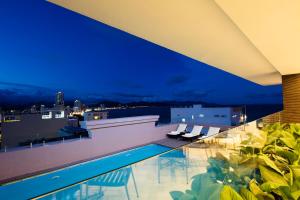a pool on the roof of a building at night at Meriton Hotel Nha Trang in Nha Trang