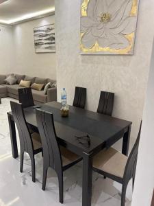 a black dining room table with chairs and a bottle of water at Appartement la Cañada in Ville Nouvelle