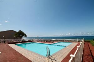 a swimming pool with the ocean in the background at Eden Dunes 68 in Shelly Beach