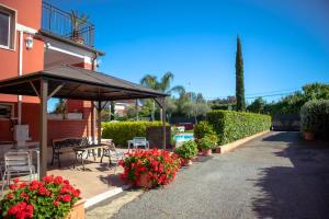 a patio with a table and umbrella and flowers at Relais Villa Italia in Selcetta